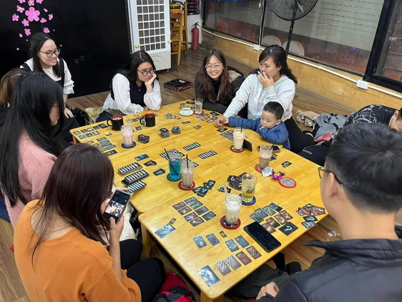 nhân viên hướng dẫn người chơi quán cafe game board